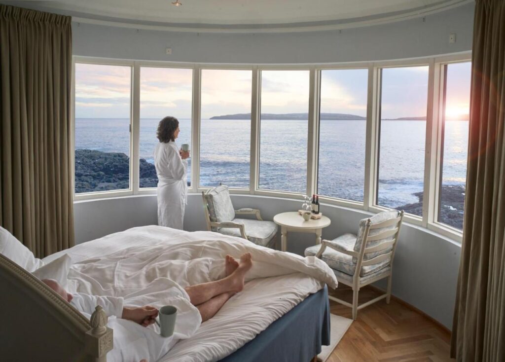 photo of Havgrim Seaside Hotel 1948 n Torshavn, just 1 km from the center, the photo shows a girl looking out the window with a panoramic view of the ocean