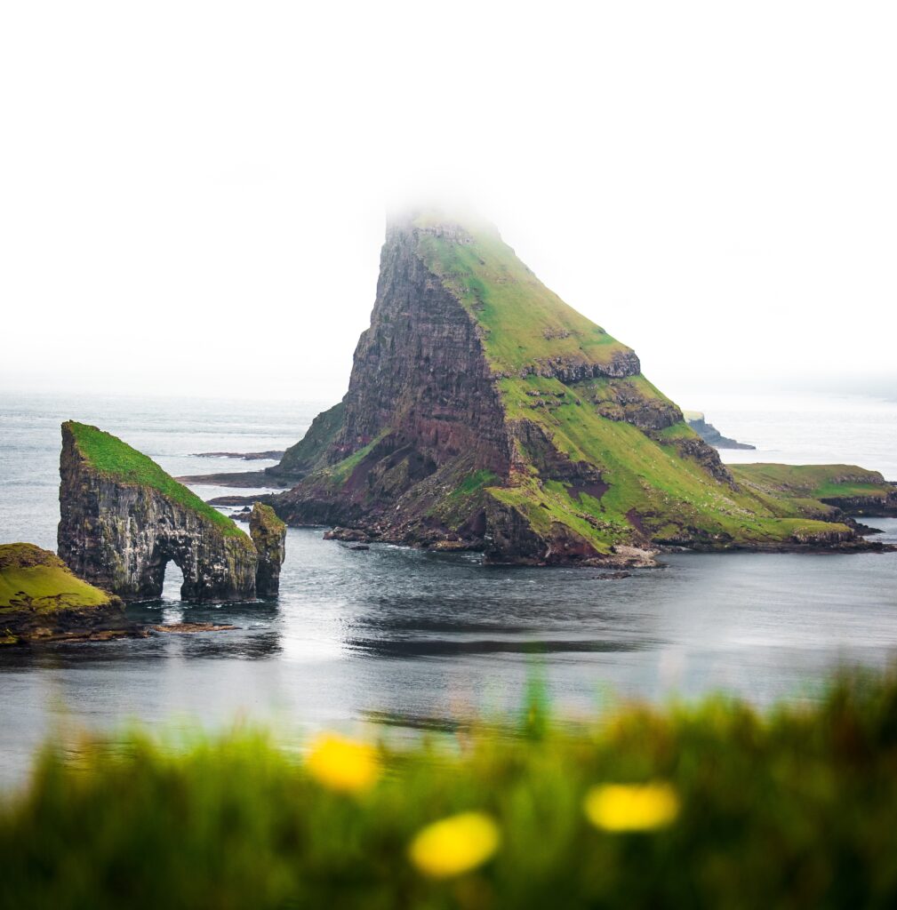 photo of uninhabited Tindhjolmur Island in the water, Faroes