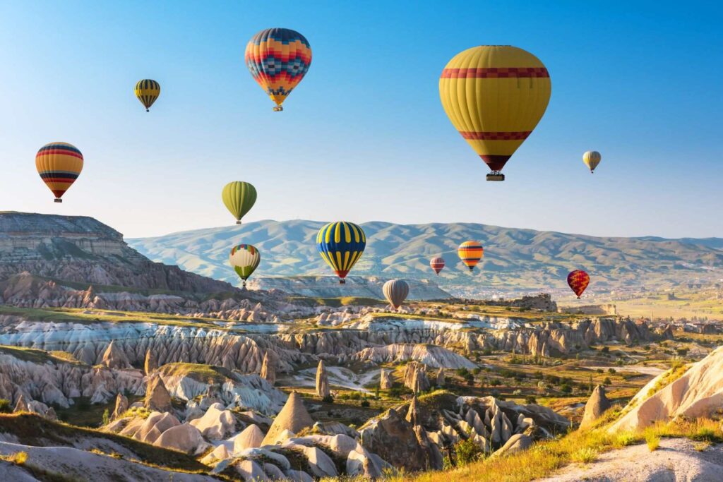 A photo taken in one of the most Instagrammed places in Turkey, Cappadocia, with many balloons flying in the background
