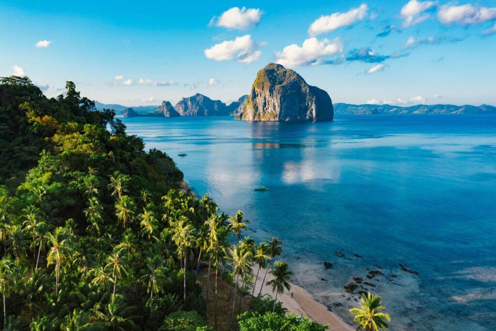 Photo of Las Cabanas Beach in El Nido on Palawan Island in the Philippines with a beautiful view of the South China Sea and palm trees