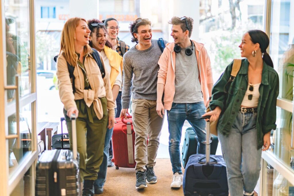 Photo of students with suitcases laughing loudly during a student trip to study in another country